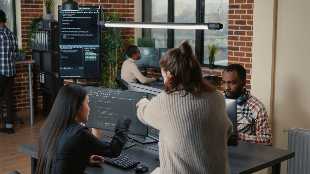 Equipo analizando código en pantallas de computadora
